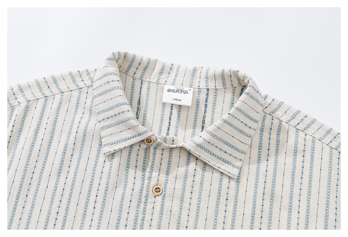 Close-up of an off-white striped shirt collar, wooden buttons, and sewn neck label.