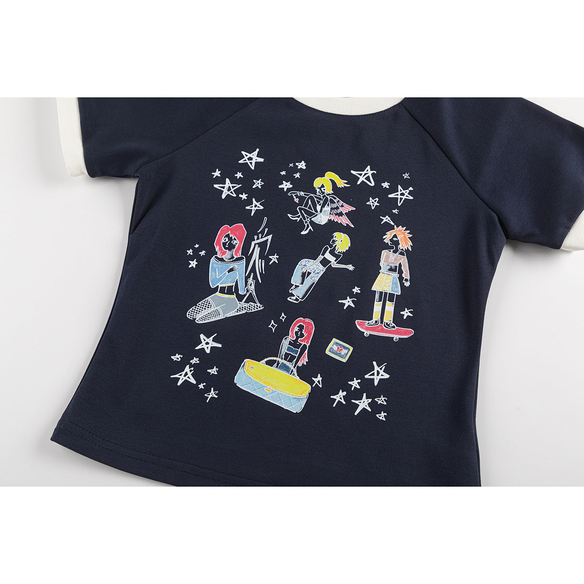 Flat lay of a navy short-sleeve shirt with cream ribbed cuffs and collar and colorful character-and-star artwork.