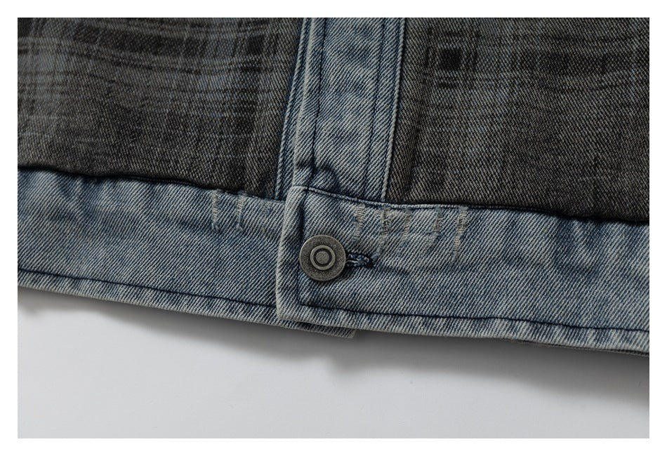 Close-up of faded blue-gray denim with a dark panel, stitched seam, and metal button.
