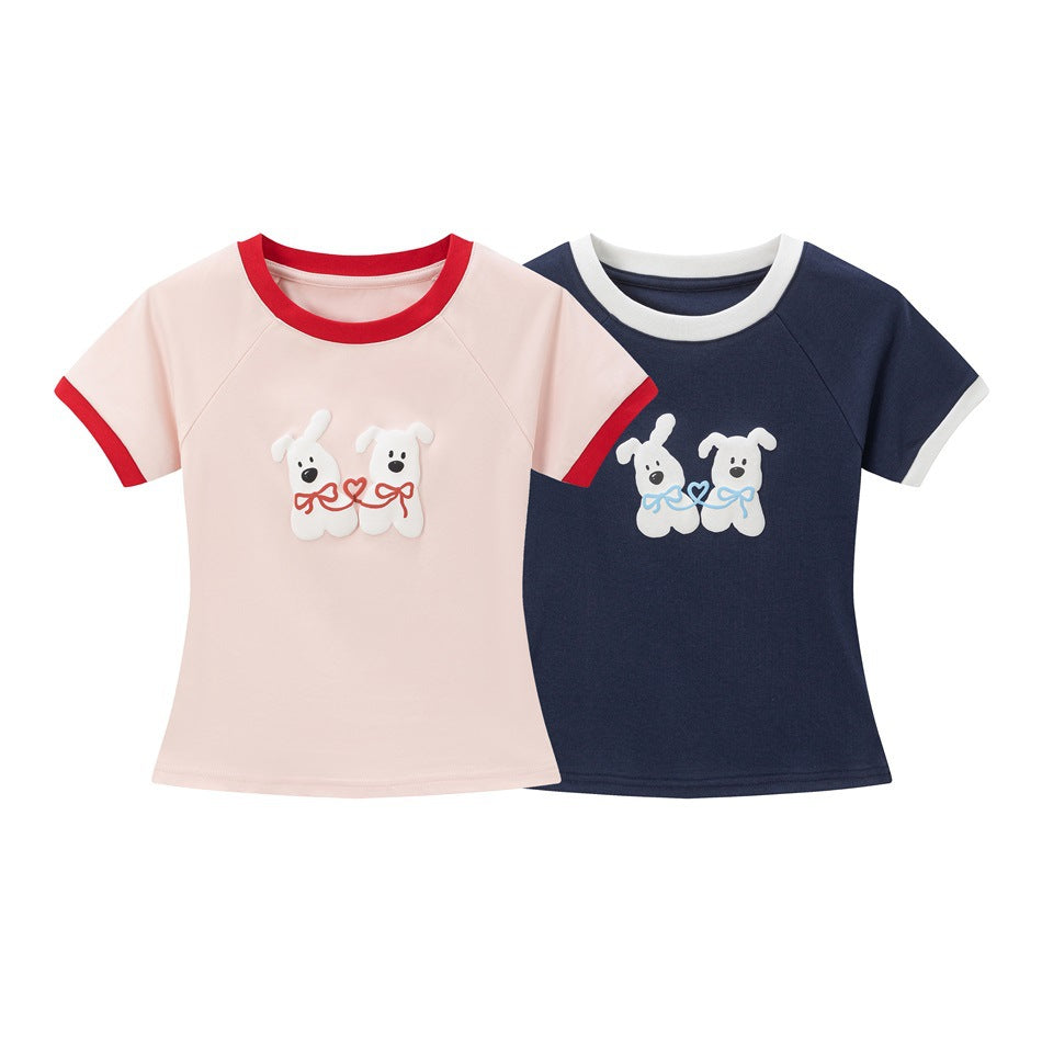 Two short-sleeve shirts shown from the front: pale pink with red trim and navy with white trim, both with white dog graphics.