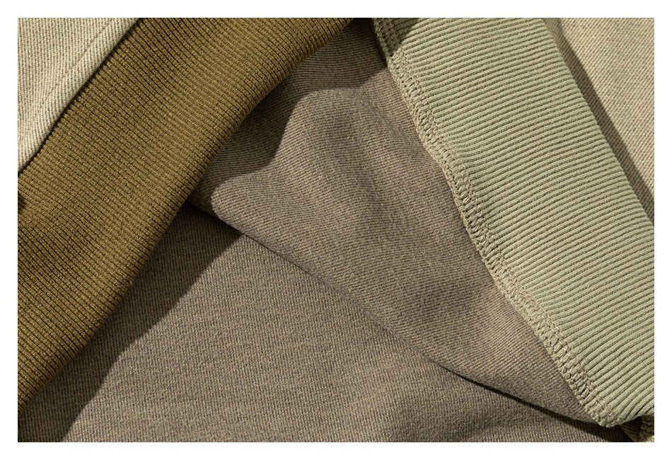Close-up of beige garment fabric beside olive-brown and sage ribbed fabric sections.