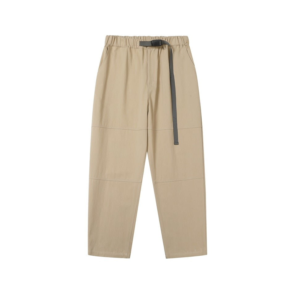 Khaki elastic-waist tapered pants with olive webbing belt, side pockets and knee seams, front flat lay