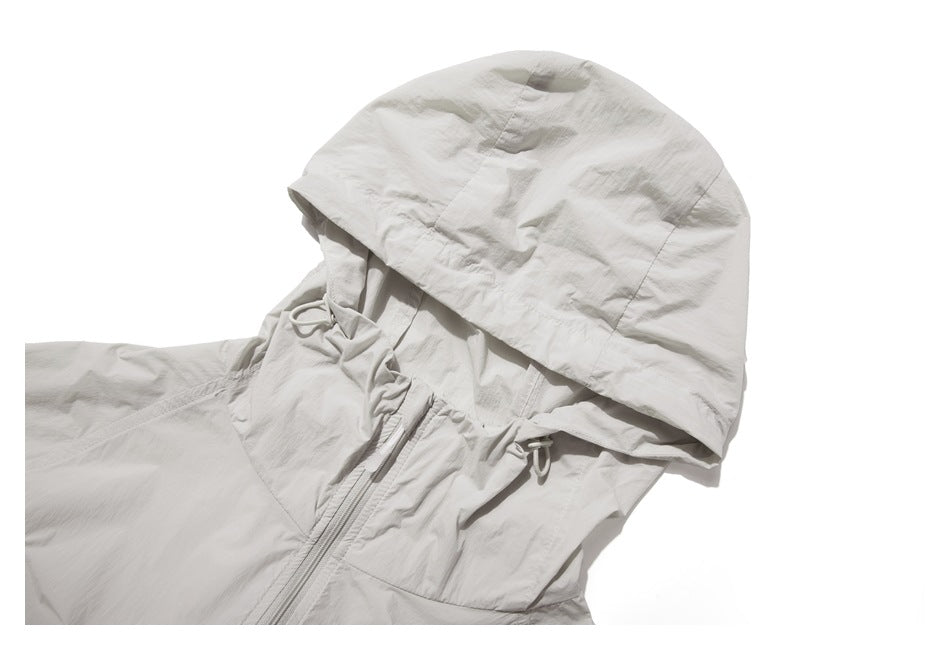 Close-up of the light gray jacket's hood, front zipper, and adjustable hood drawcords.