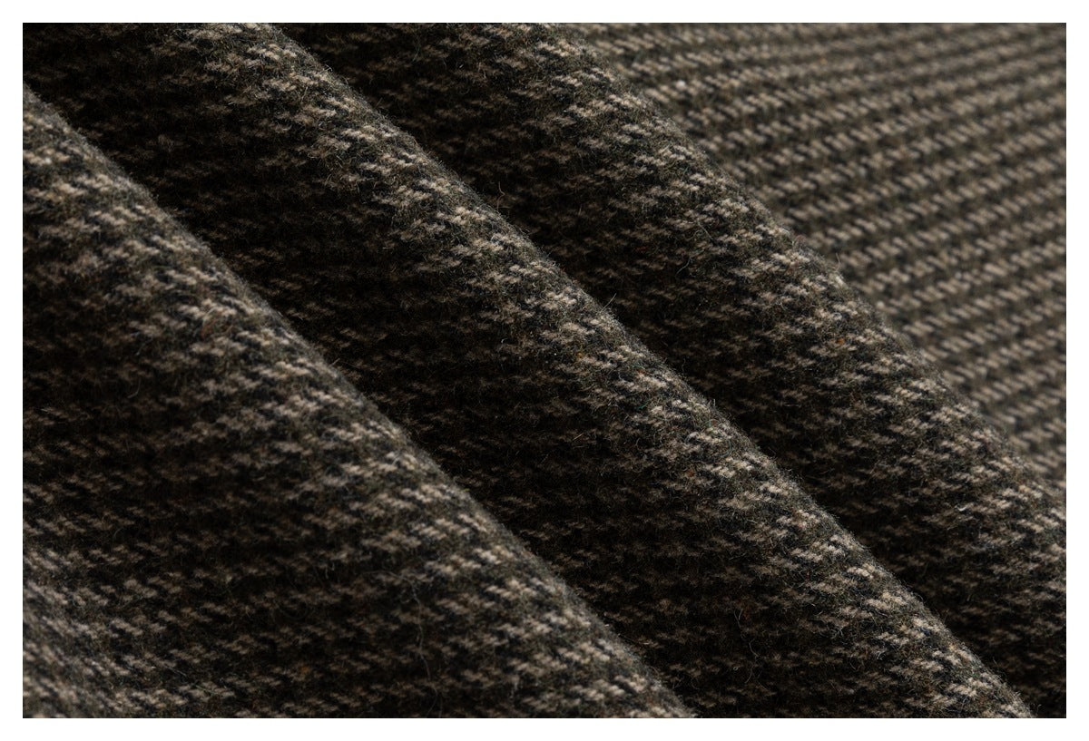 Macro view of the jacket’s brown and charcoal herringbone fabric texture.