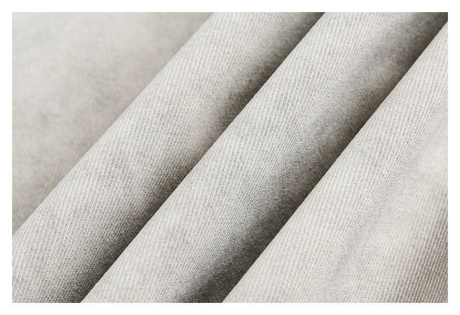 Close-up of light gray fabric arranged in soft folds.