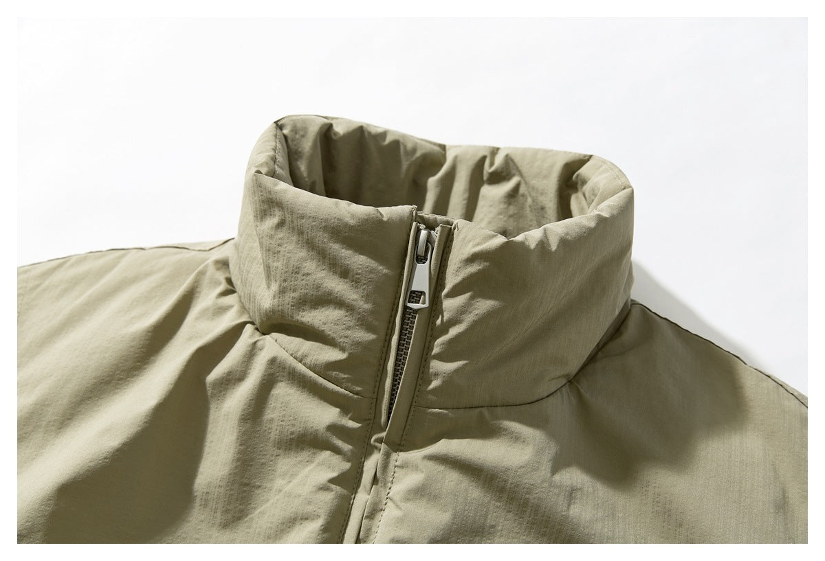 Close-up of an olive-khaki jacket’s tall stand collar and front zipper.