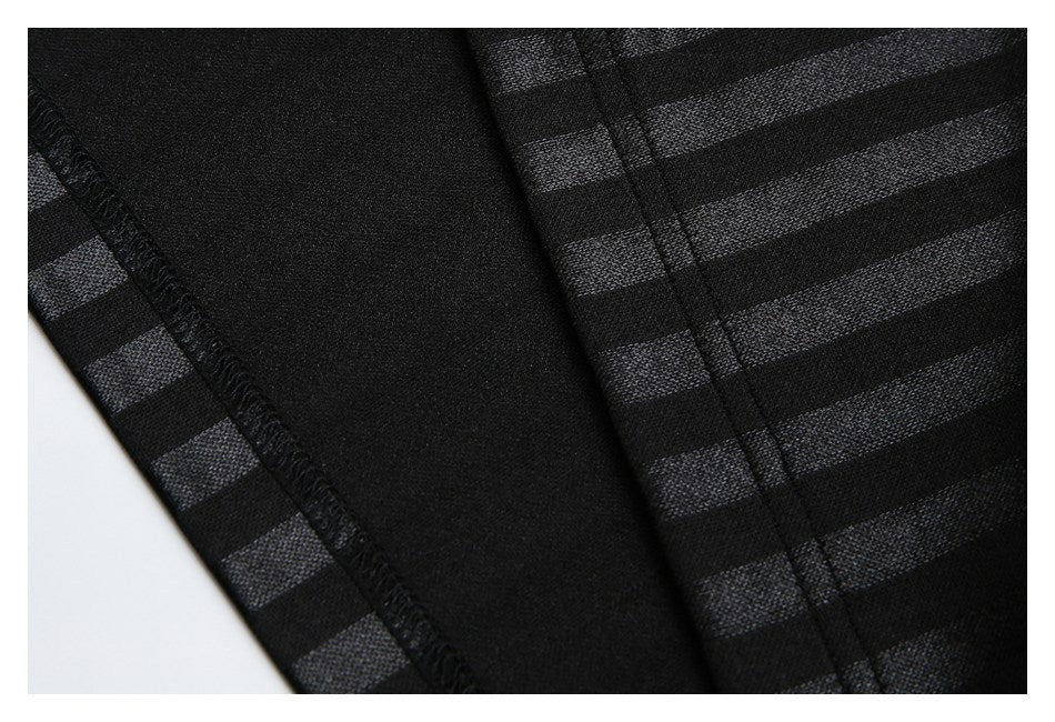 Close-up of black striped garment fabric showing an overlocked seam and inner panel.