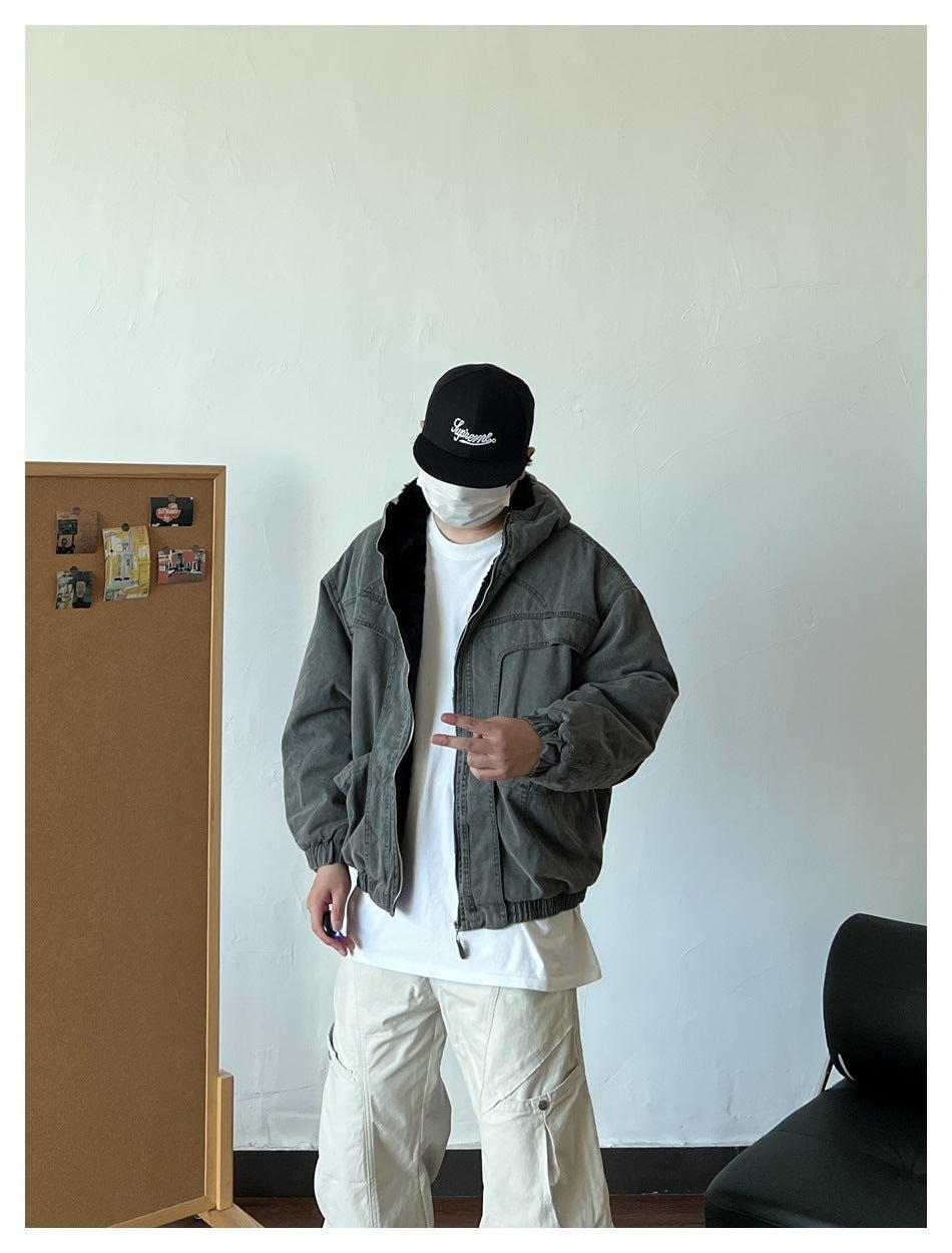 Person wearing a charcoal-gray hooded jacket with front pockets and dark lining, shown from the front.