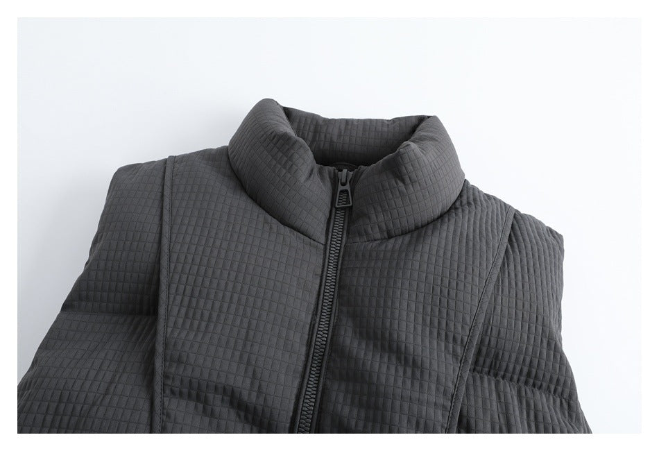 Close-up of a charcoal quilted vest showing its high padded collar and front zipper.