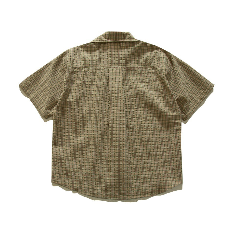 Back view of olive green and tan plaid short-sleeve shirt with yoke and center pleat, flat lay