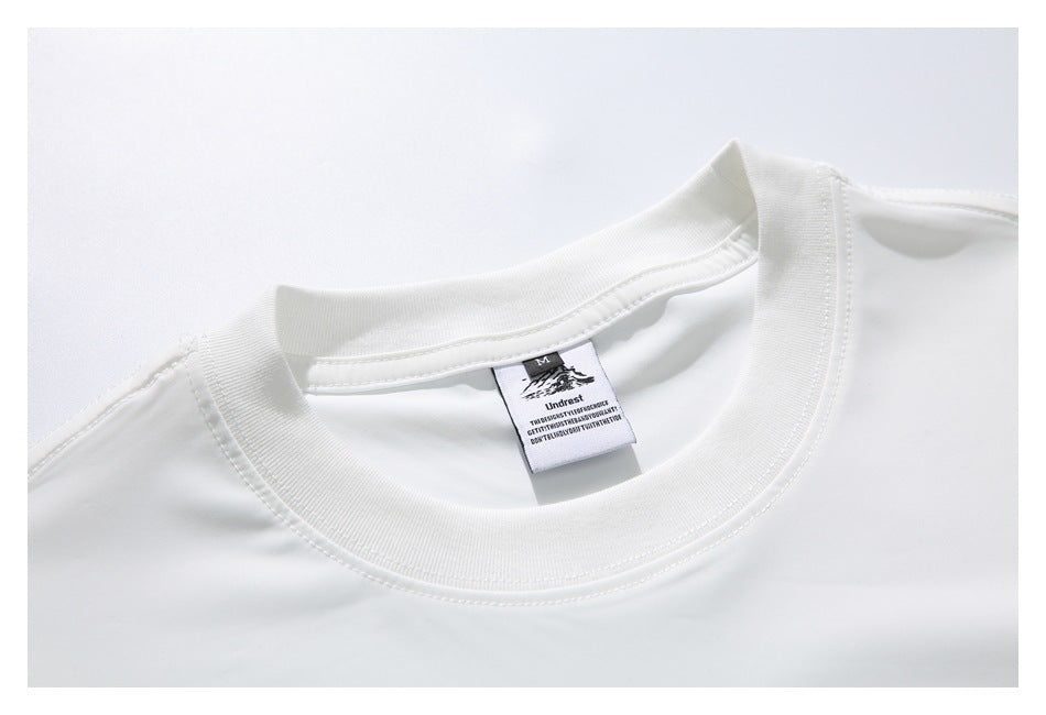 Close-up of a white shirt’s ribbed crew neckline and inner size and brand label.