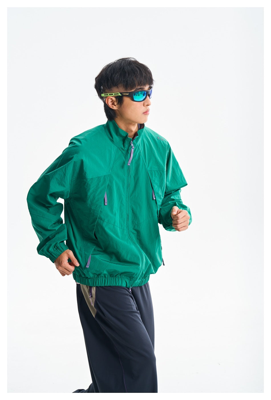 Model in a teal zip-front jacket with elastic cuffs and hem, posed against a white background.