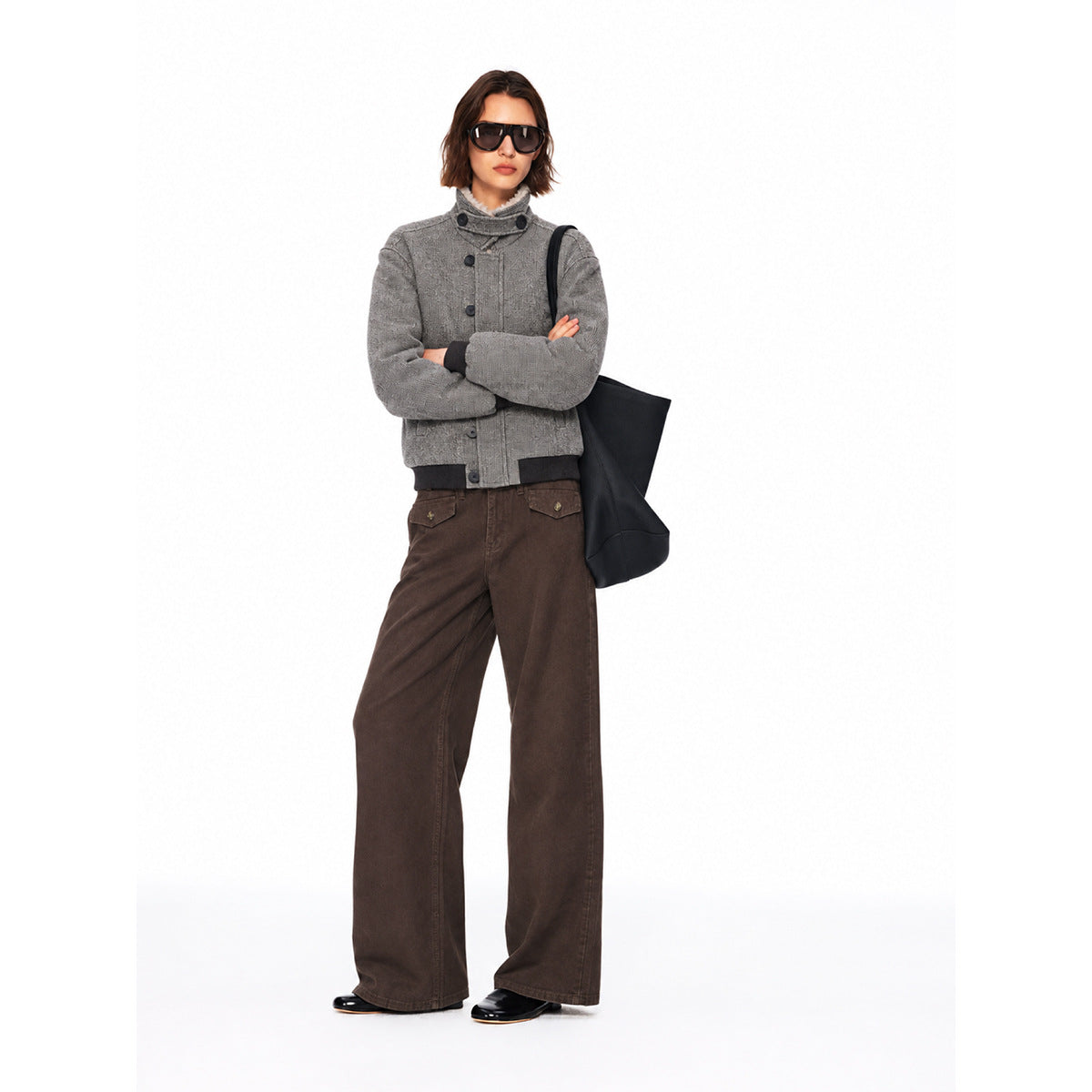 Model wearing a gray button-front jacket with black ribbed cuffs and hem, and wide-leg brown pants.