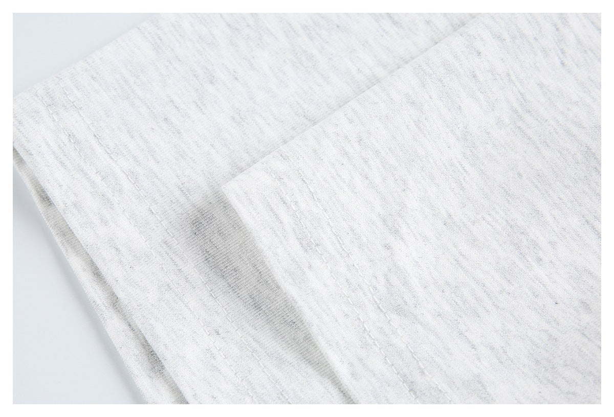 Close-up of folded white heathered knit fabric with parallel stitched edges.