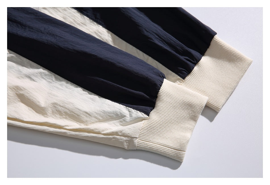 Close-up of navy and ivory garment sleeves ending in wide, ribbed ivory cuffs.