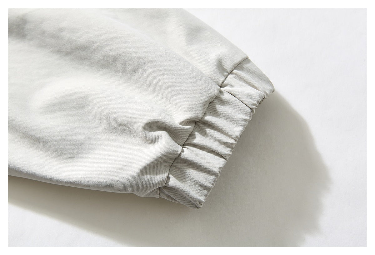 Close-up of an off-white jacket sleeve ending in a gathered elastic cuff.