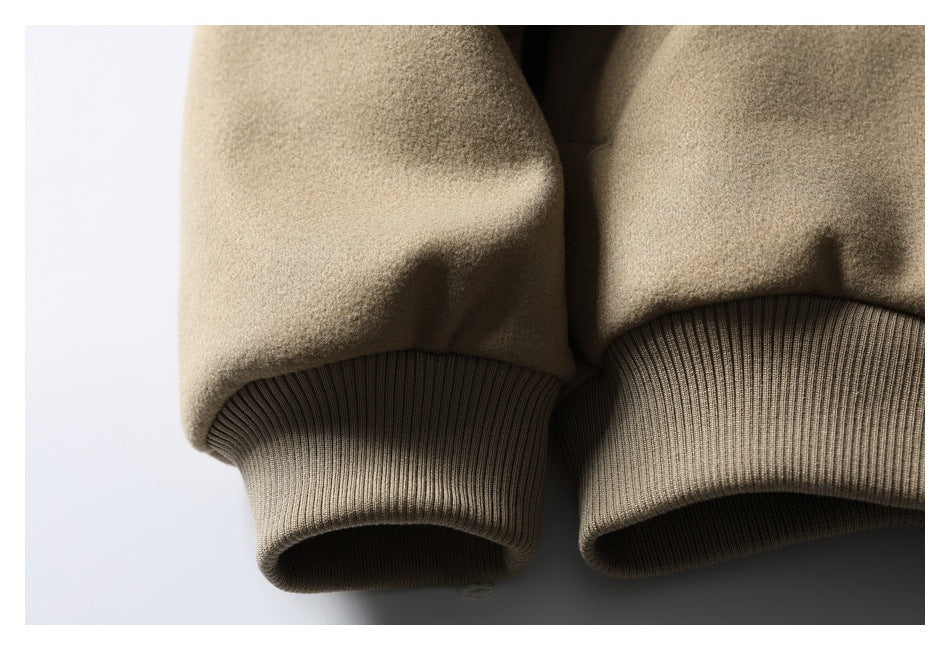 Close-up of the taupe jacket's sleeve and ribbed cuff beside its ribbed hem.
