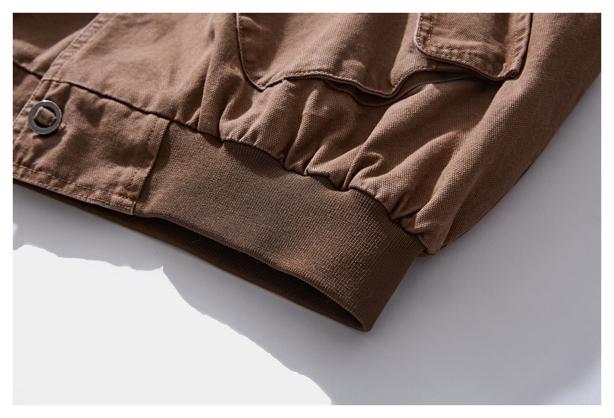 Close-up of the brown jacket's gathered lower edge and dark ribbed waistband.