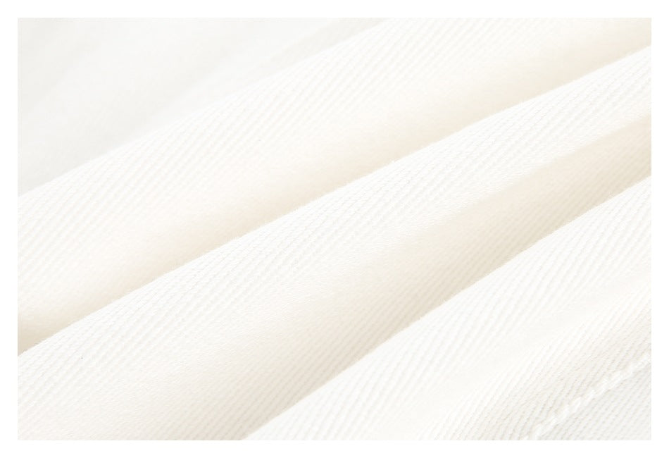 Close-up of off-white fabric with a fine diagonal ribbed weave.