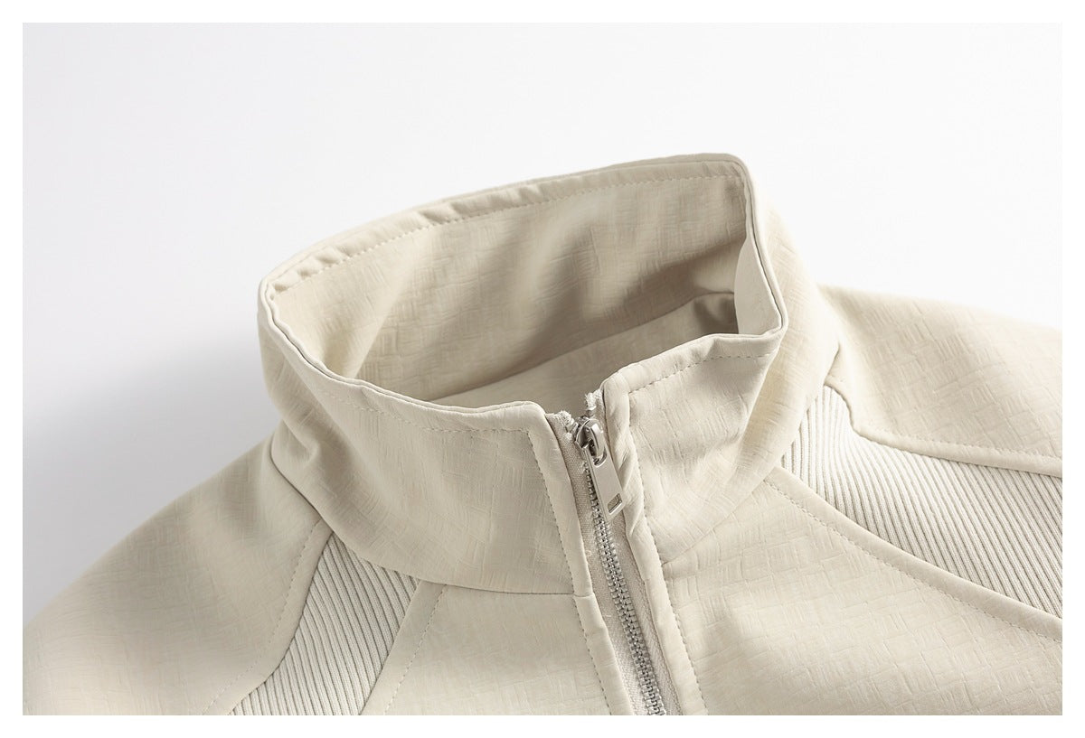 Close-up of an ivory jacket's high collar and silver front zipper.