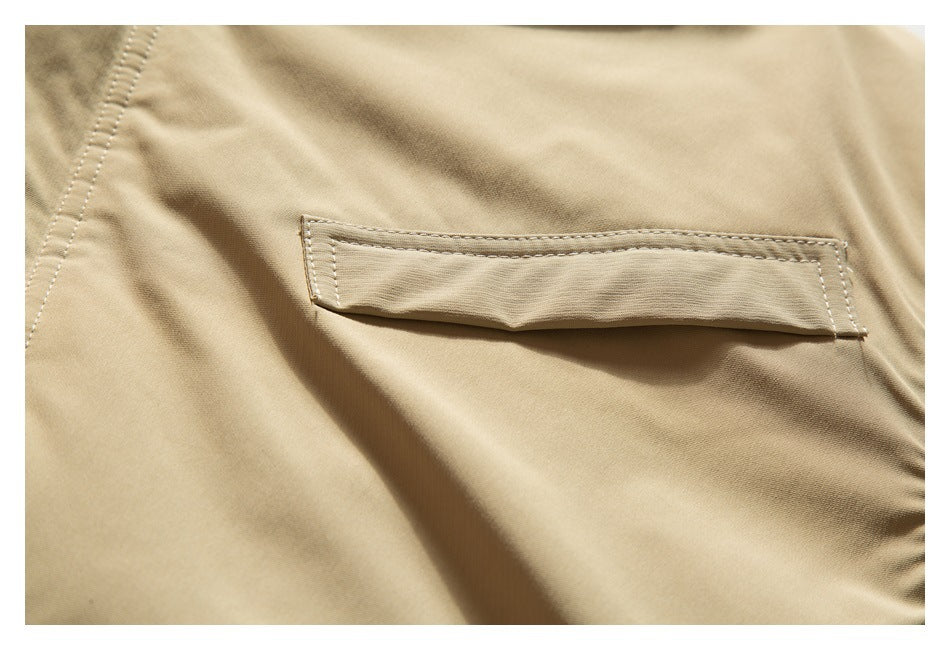 Close-up of a stitched horizontal flap pocket on the tan jacket.