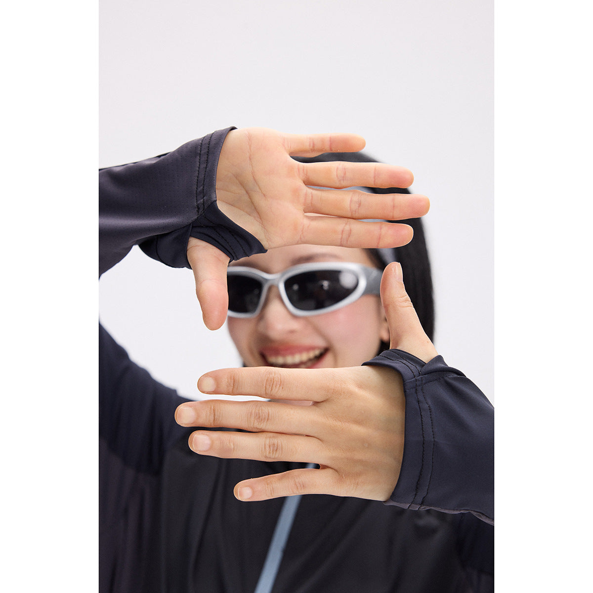 Close-up showing the dark top's long sleeves with thumbhole cuffs.