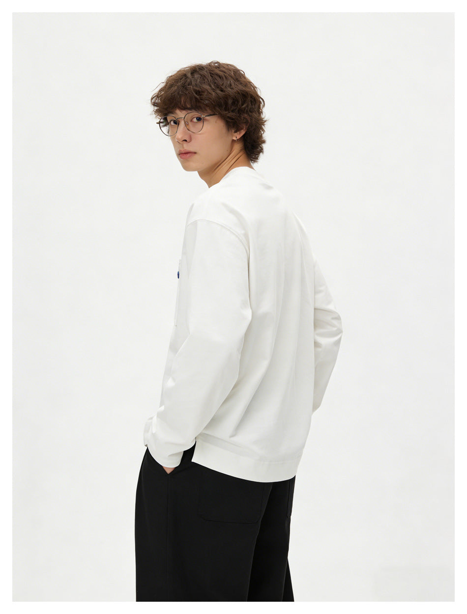 Back three-quarter view of a model wearing a white long-sleeve crewneck top and black trousers.