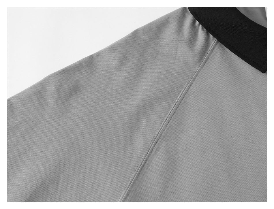 Close-up of a gray polo shirt’s shoulder seam, sleeve, and black collar.
