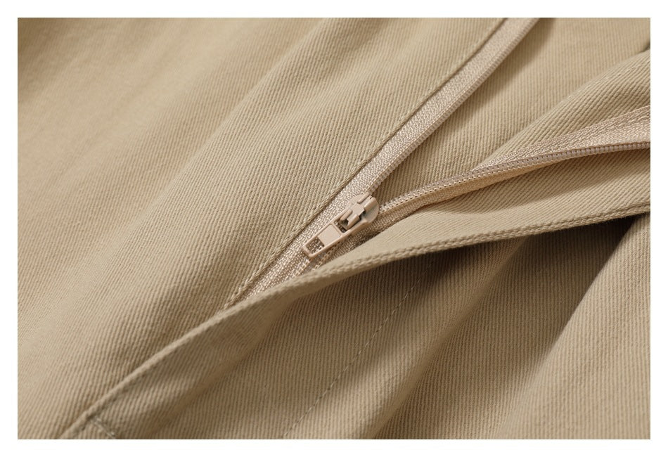 Close-up of a zipper and stitched seam on the tan pants.