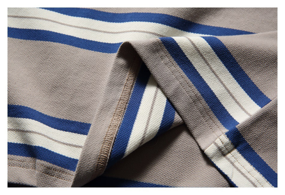 Close-up of the T-shirt’s striped fabric, folded hem, and overlock stitching.