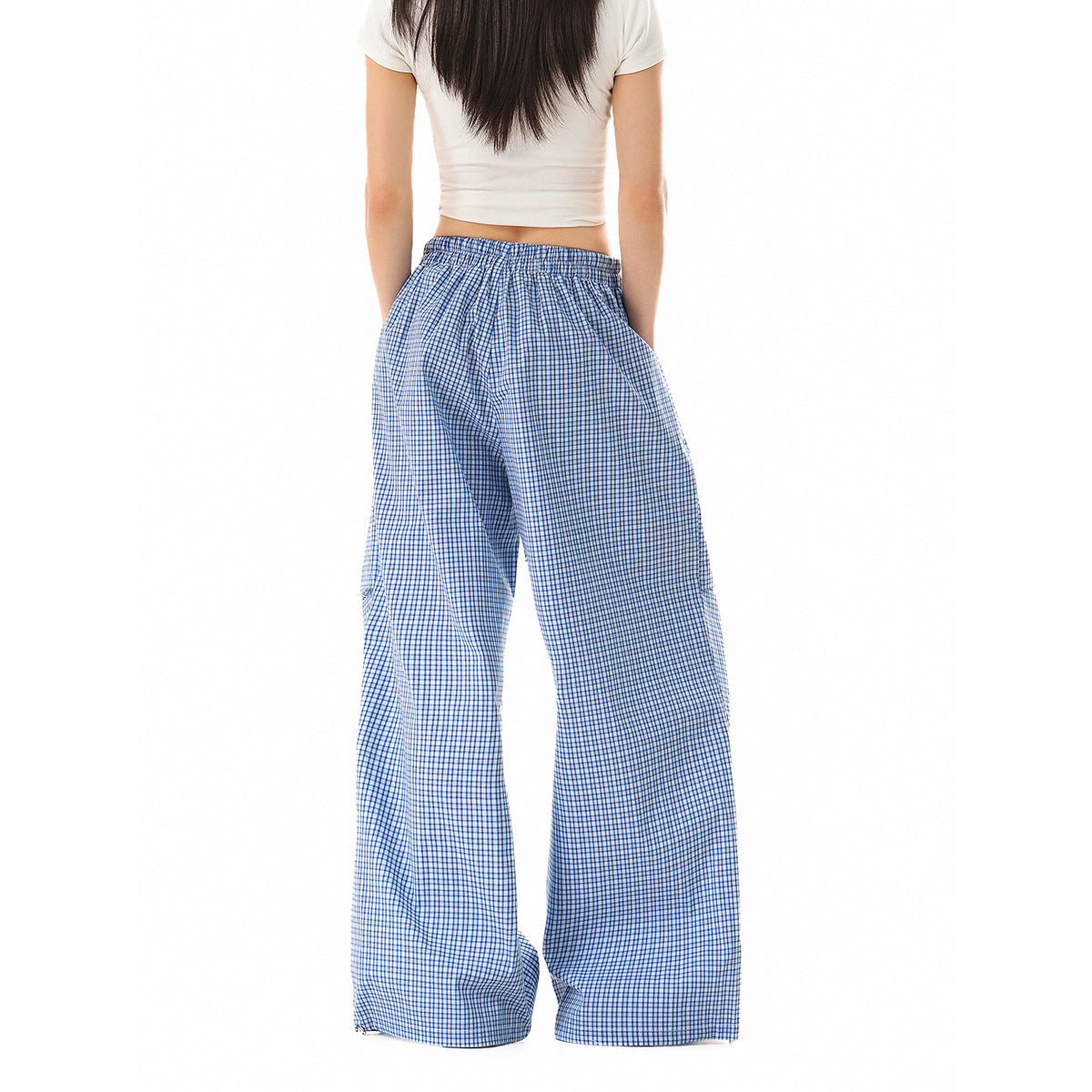 Back view of a model wearing loose blue-and-white check pants with an elastic waist.