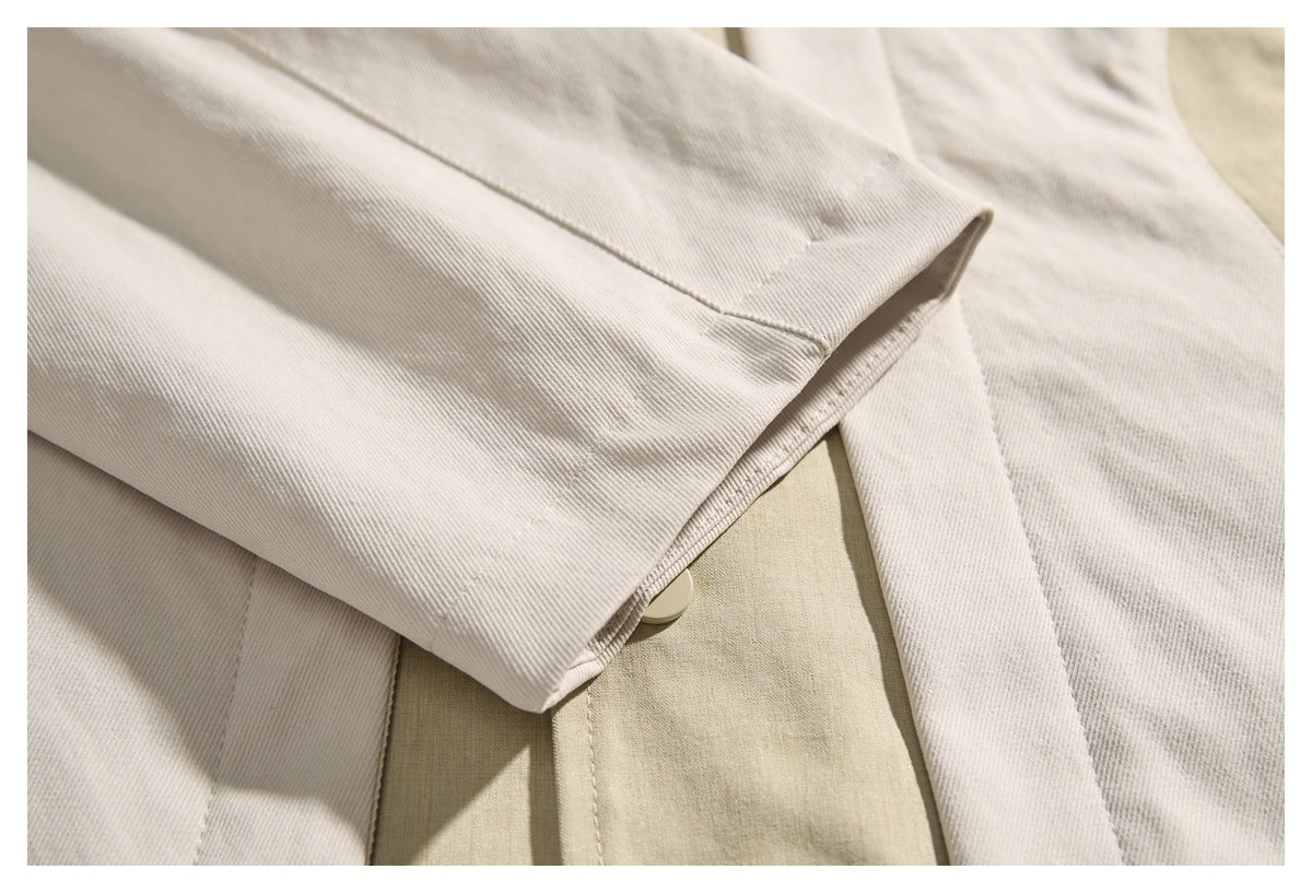 Close-up of a cream jacket sleeve cuff layered over its beige front panel.