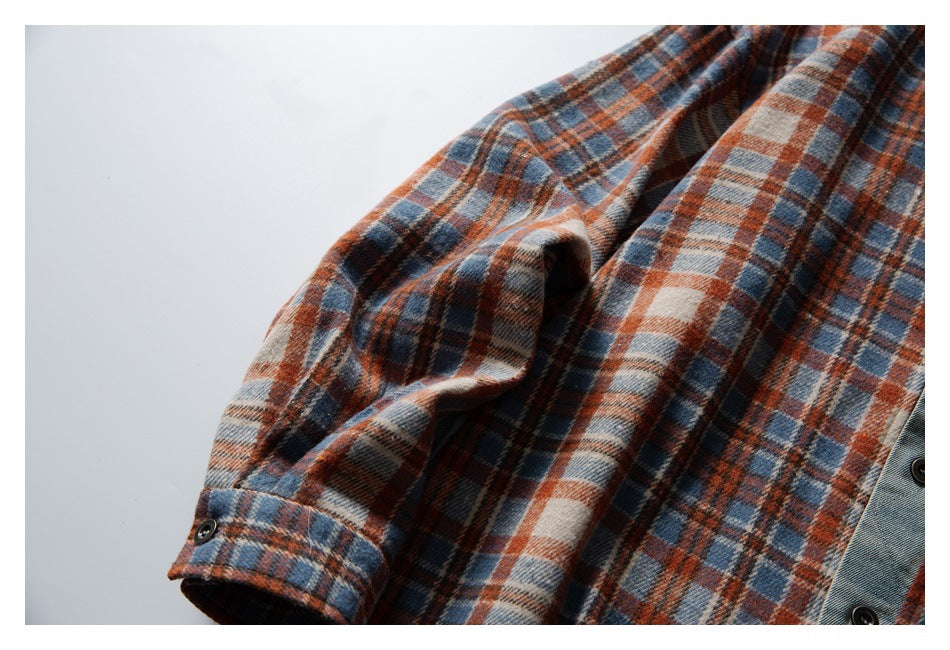 Close-up of the plaid shirt sleeve and cuff against a light background.