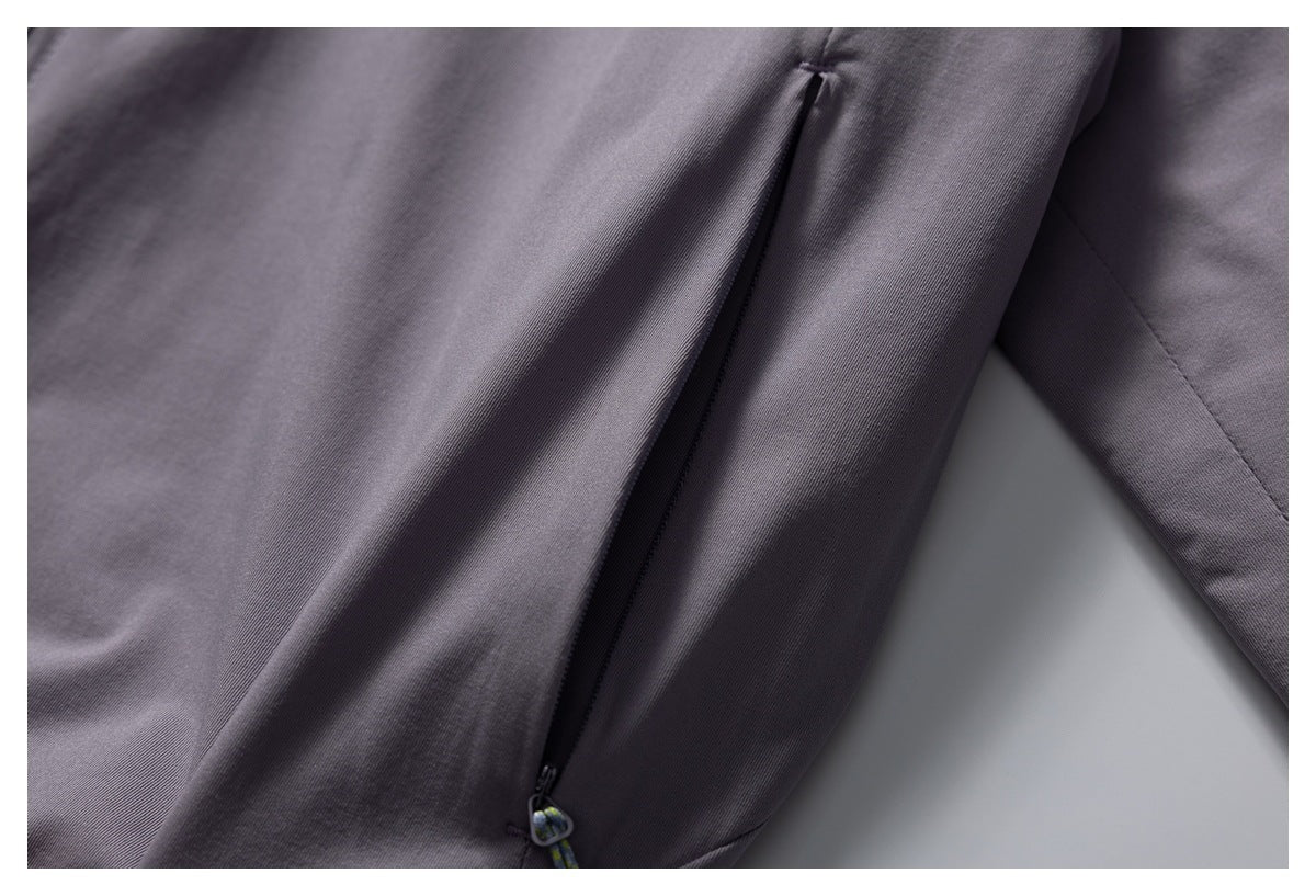 Close-up of a dark zippered pocket on the purple jacket.