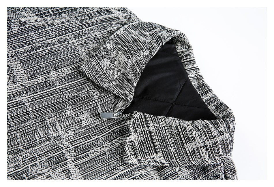 Close-up of the jacket's abstract black-and-white pattern, dark lining, collar, and zipper.