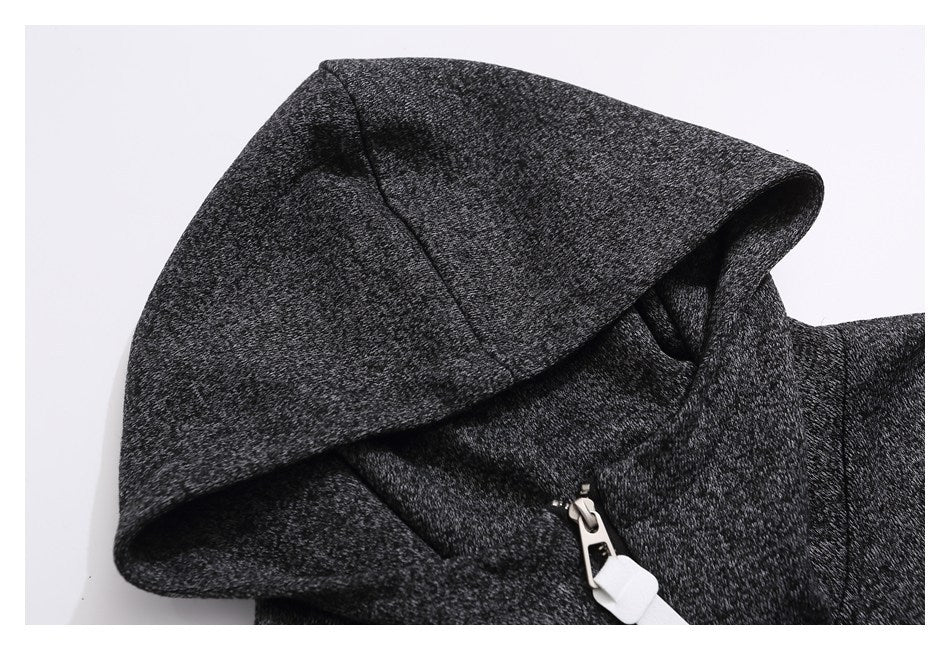 Close-up of a charcoal marled hoodie showing the hood and short front zipper with a white pull.