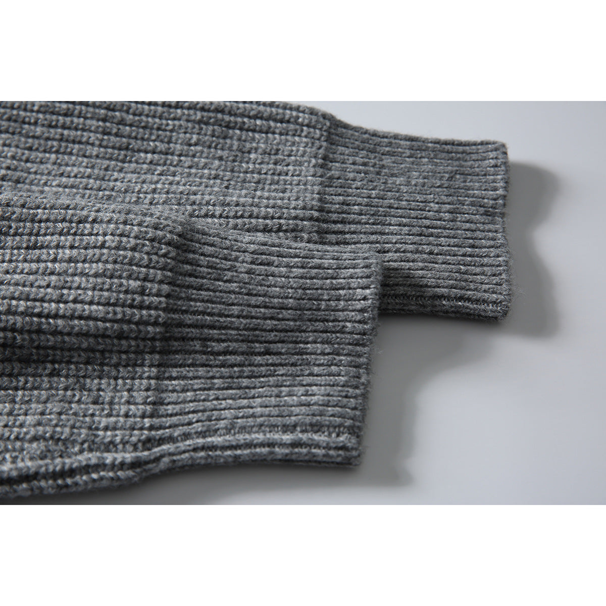 Close-up of the gray rib-knit sweater sleeves and cuffs.