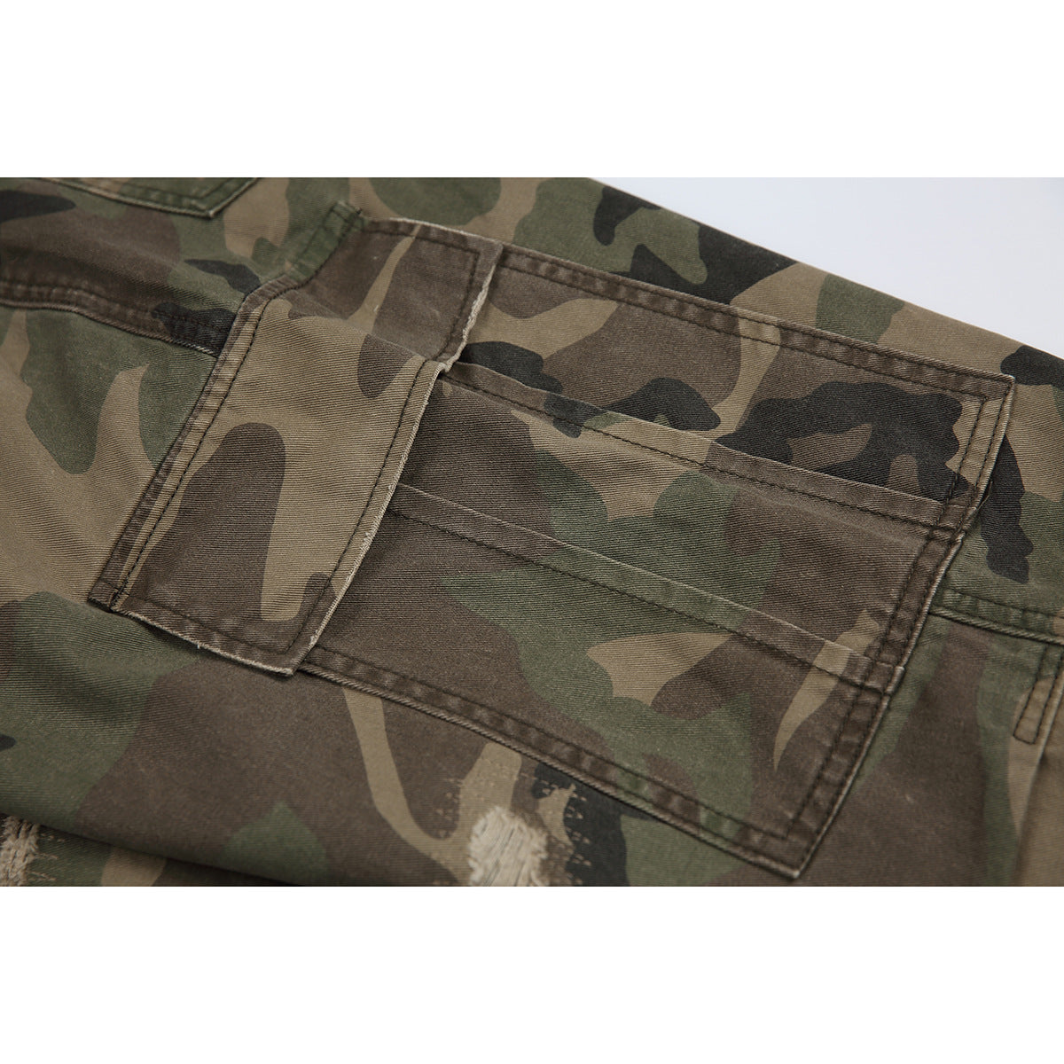Close-up of a large flap pocket on the back of olive, brown and black camouflage trousers.