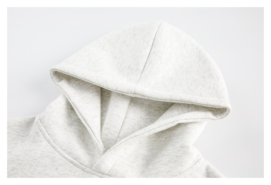 Close-up of the hood and neckline of a light heather gray pullover hoodie.