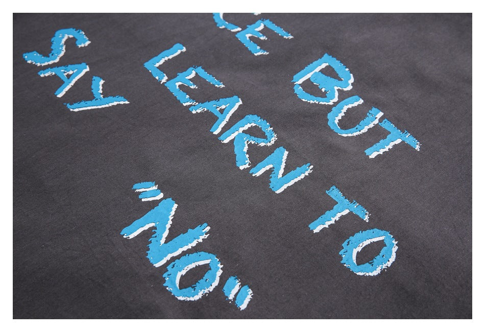 Close-up of charcoal fabric with distressed blue and white lettering printed across it.