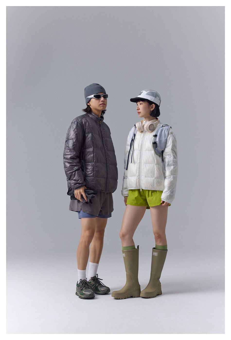 Two models wear quilted zip jackets: one white and one charcoal gray.
