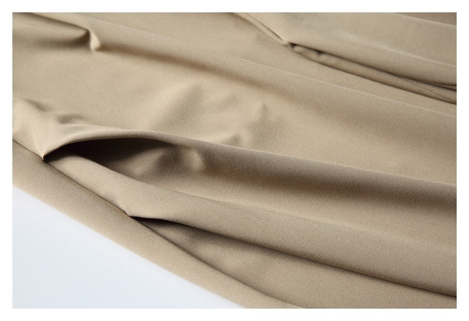 Close-up of the smooth beige trouser fabric and a folded section.