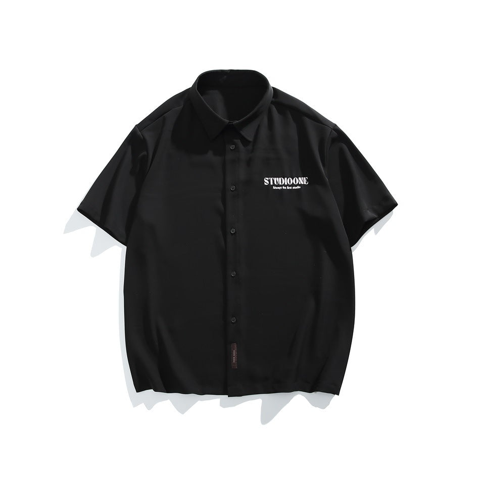 Black short-sleeve button-up shirt with collar and small white chest print, flat lay front view