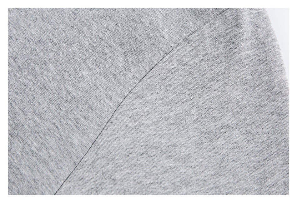 Close-up showing a curved seam on the heather gray knit garment.