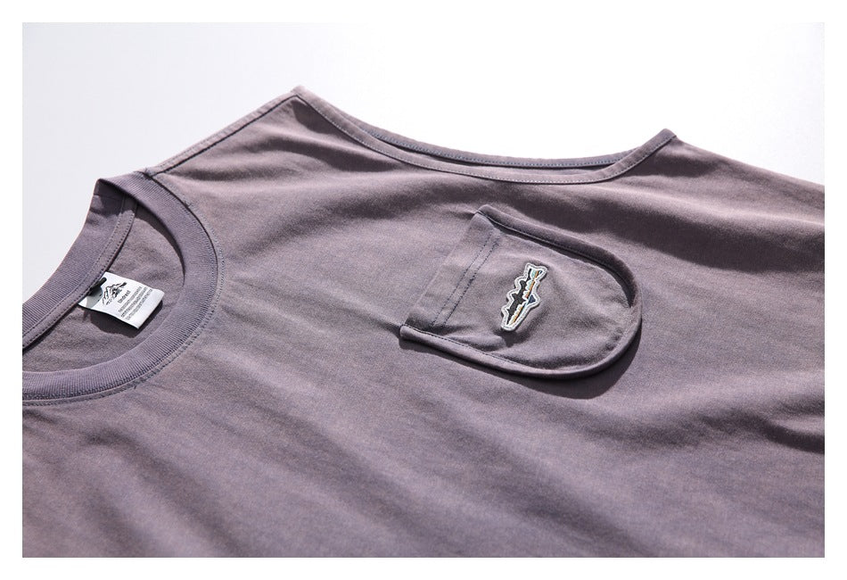 Close-up of the shirt's crew neck and chest pocket with an embroidered patch.