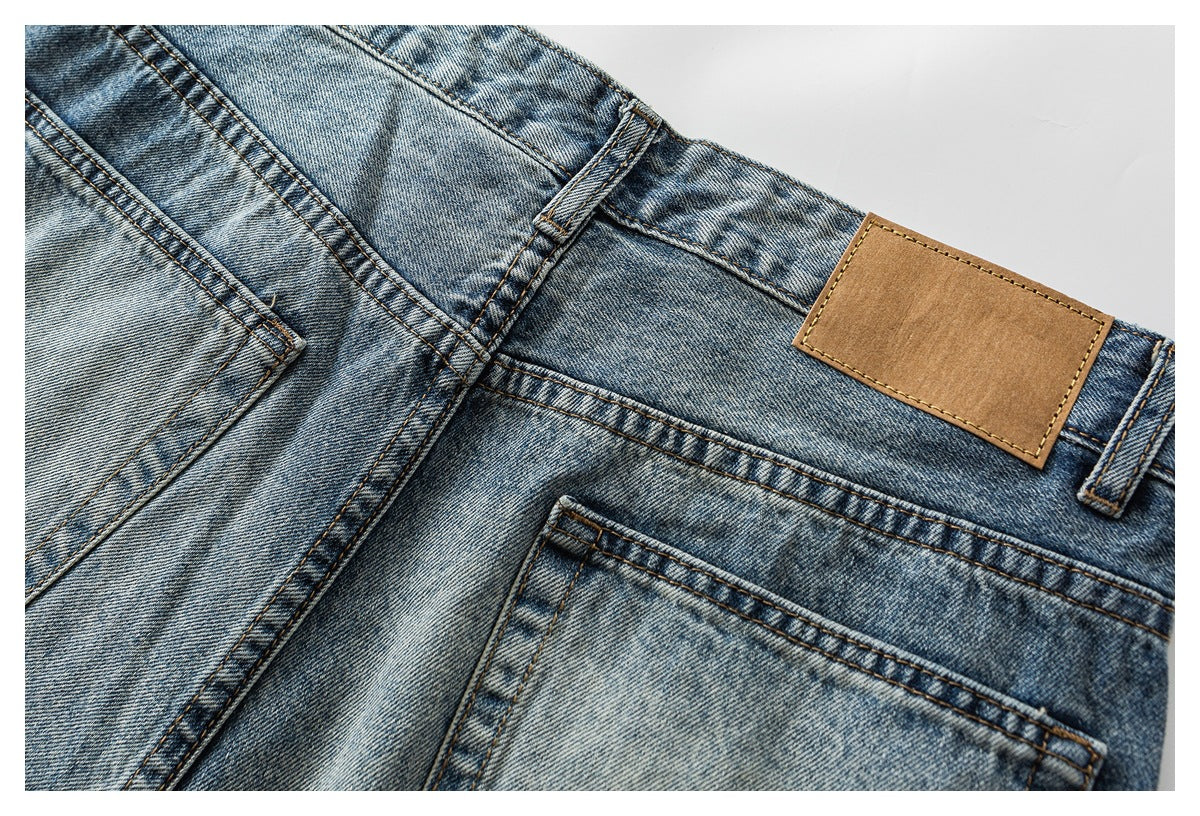 Close-up of the back of faded blue jeans, showing a pocket, belt loops and a blank tan waistband patch.