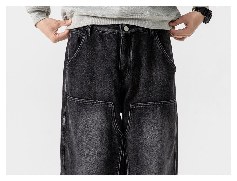 Front view of a person wearing black wide-leg jeans with large front patch pockets and a button waist.