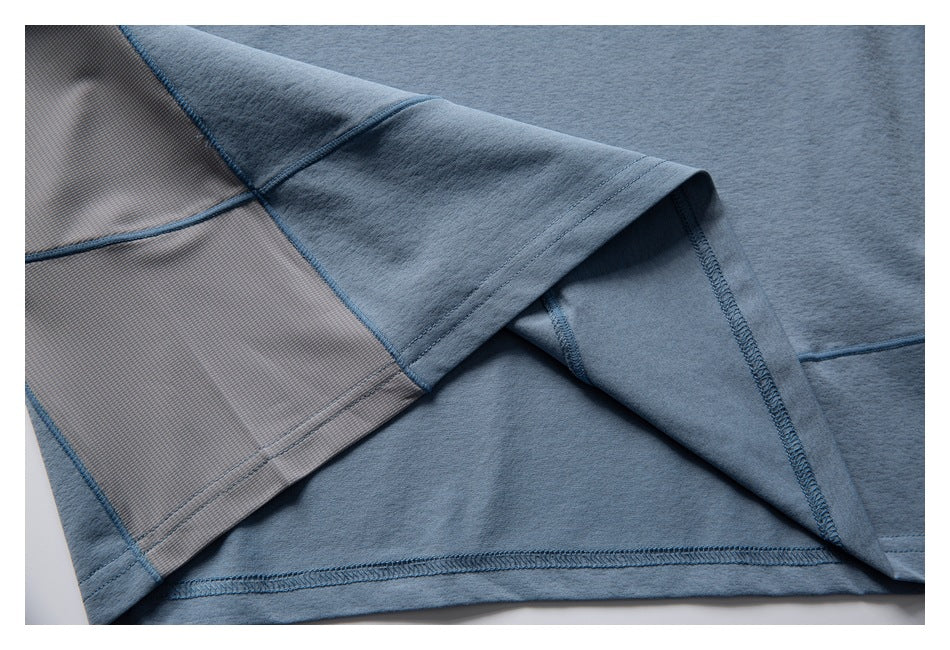 Close-up of the blue garment's turned hem, showing interior stitching and a gray textured panel.