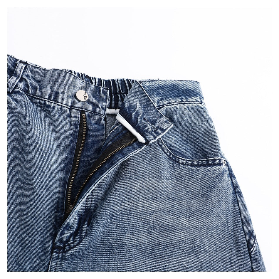 Close-up of blue acid-wash jeans with the waistband unbuttoned and the zipper fly open.