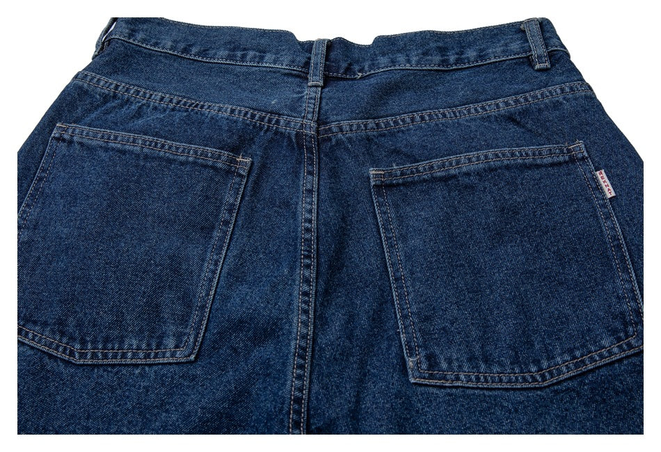 Rear view of dark blue jeans showing the waistband, belt loops, and two large patch pockets.